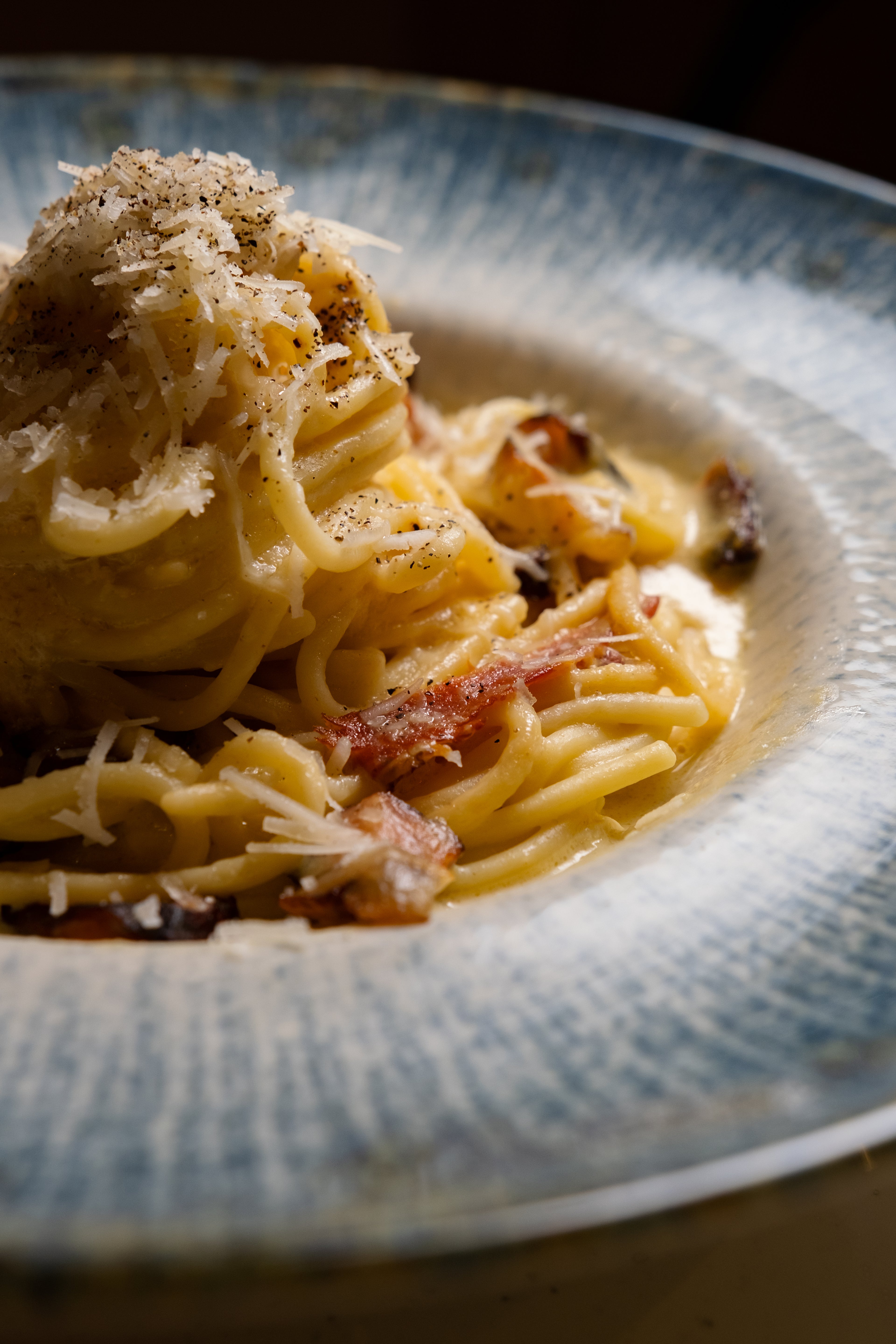 Spaghetti carbonara on a textured ceramic plate